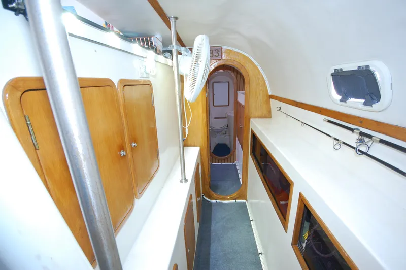 Slide: The Image of Interior of 1999 Wildcat 35 Catamaran with wooden cabinets and fishing rods. - 40