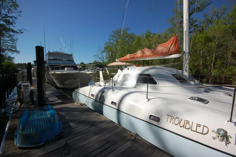 Slide: The Image of 1999 Wildcat 35 Catamaran docked with other boats on a sunny day. - 9