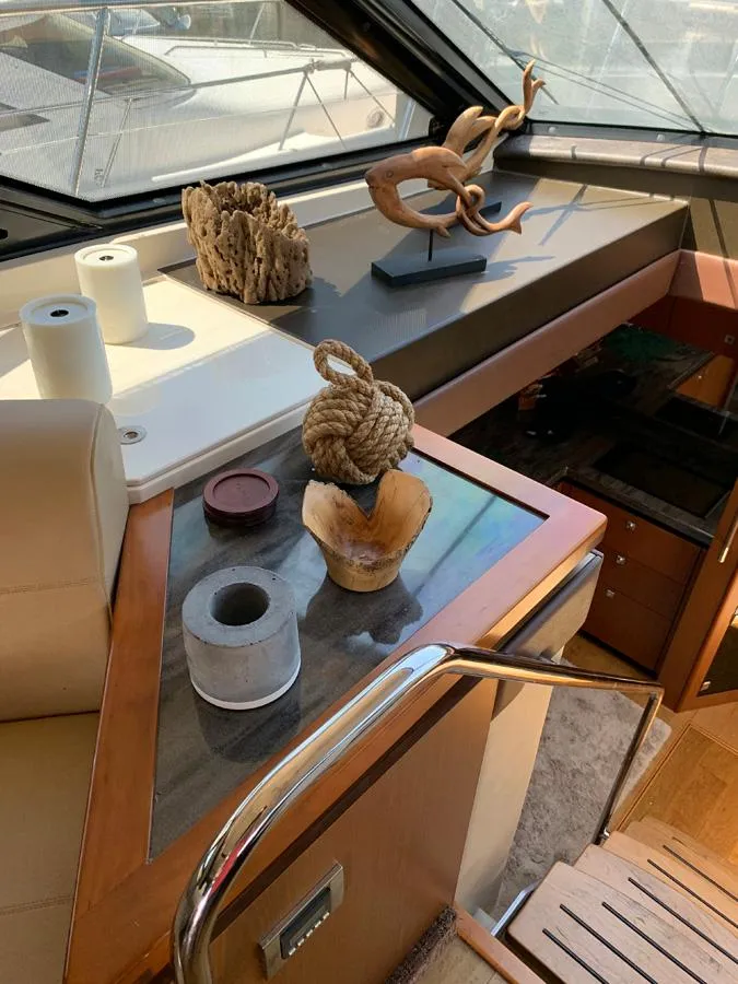 Slide: The Image of Interior of 2014 Sea Ray 510 Sundancer yacht with decorative items on table. - 24