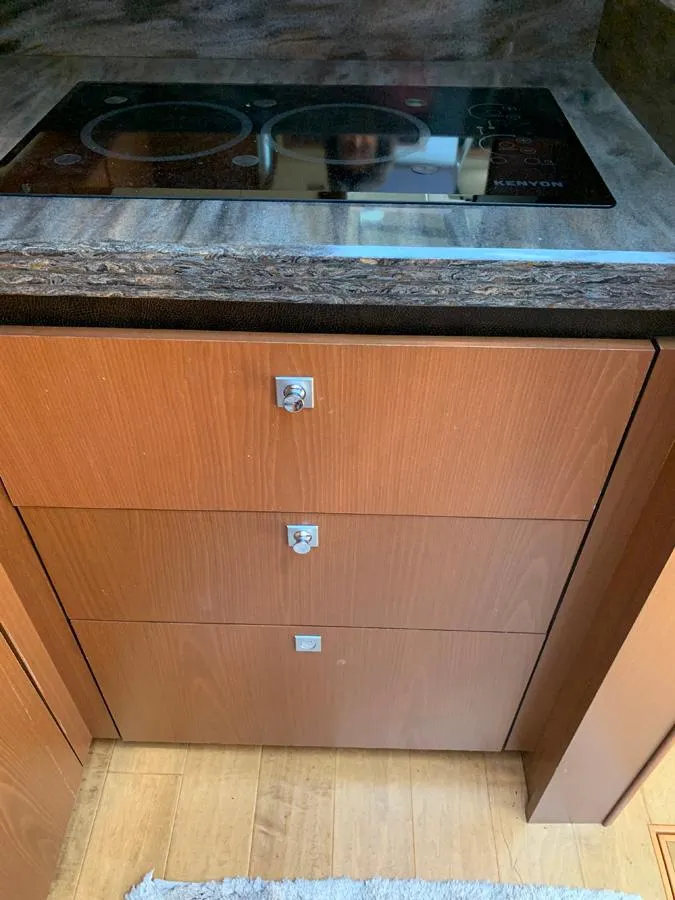 Slide: The Image of Modern kitchen area in 2014 Sea Ray 510 Sundancer yacht with stovetop and wooden cabinets. - 26