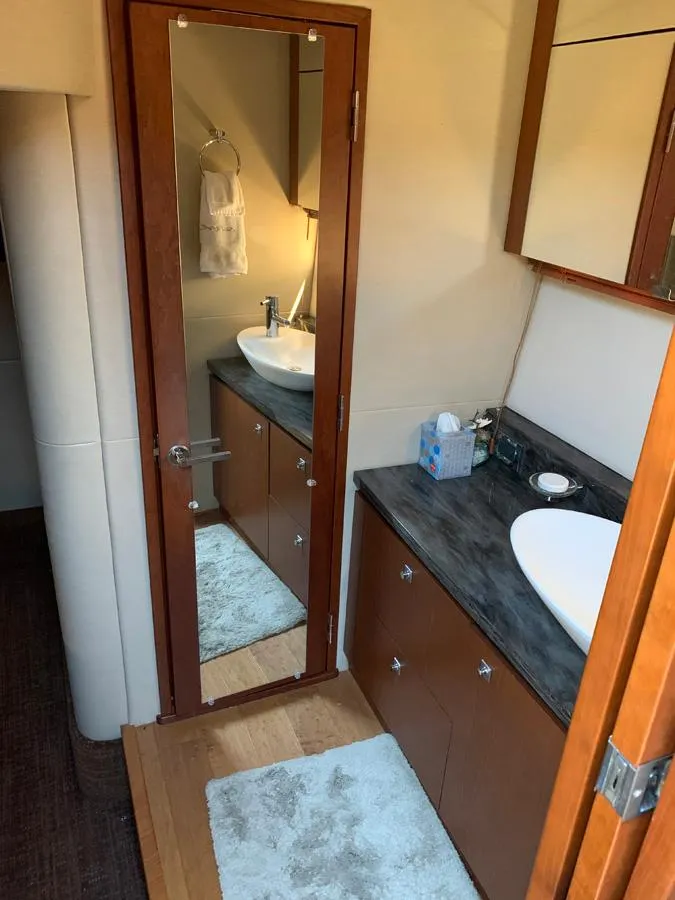 Slide: The Image of 2014 Sea Ray 510 Sundancer bathroom with mirror, sink, and wooden cabinets. - 29