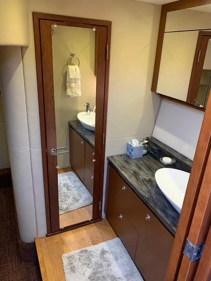 Slide: The Image of 2014 Sea Ray 510 Sundancer bathroom with modern fixtures and wooden cabinetry. - 33