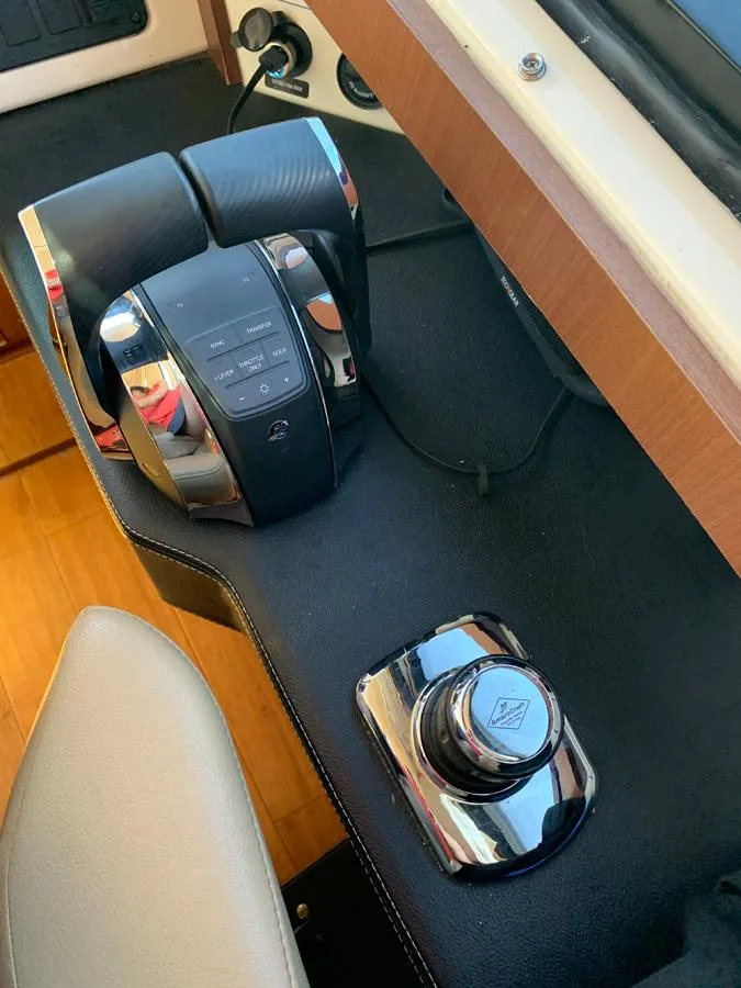 Slide: The Image of 2014 Sea Ray 510 Sundancer helm controls and joystick on black console. - 6