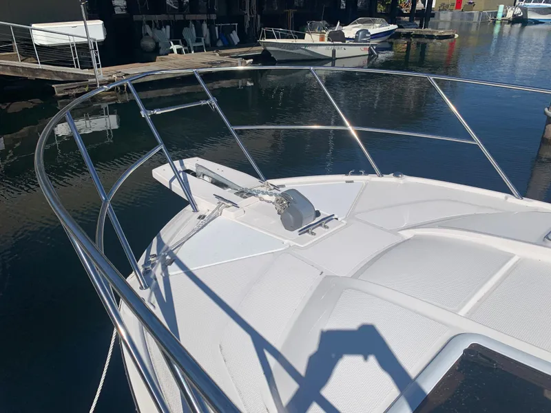 Slide: The Image of 2022 Cutwater C-24 Coupe boat bow with stainless steel railings at a marina. - 11
