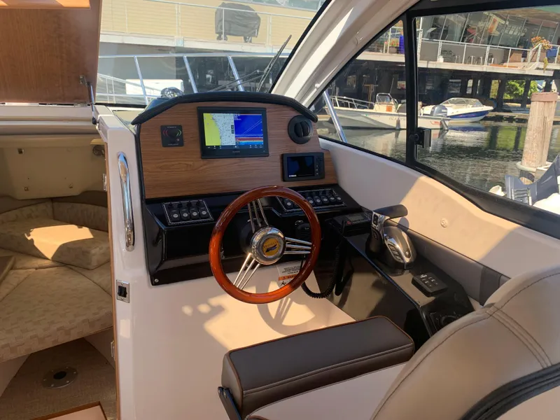 Slide: The Image of 2022 Cutwater C-24 Coupe helm with wood accents and modern navigation system. - 16