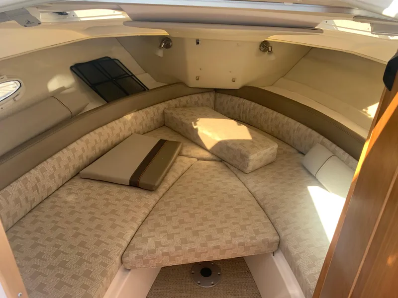 Slide: The Image of 2022 Cutwater C-24 Coupe interior cabin with beige seating and cushions. - 17