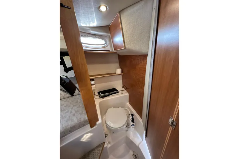 Slide: The Image of 2022 Cutwater C-24 Coupe boat interior bathroom with wooden cabinetry and compact design. - 26