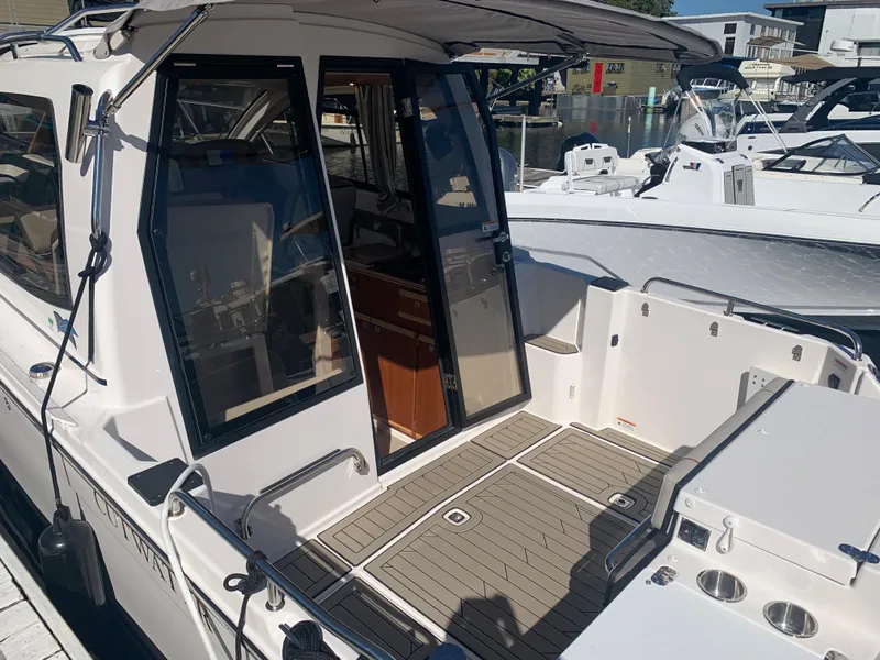 Slide: The Image of 2022 Cutwater C-24 Coupe boat with open cabin doors, docked at a marina. - 6