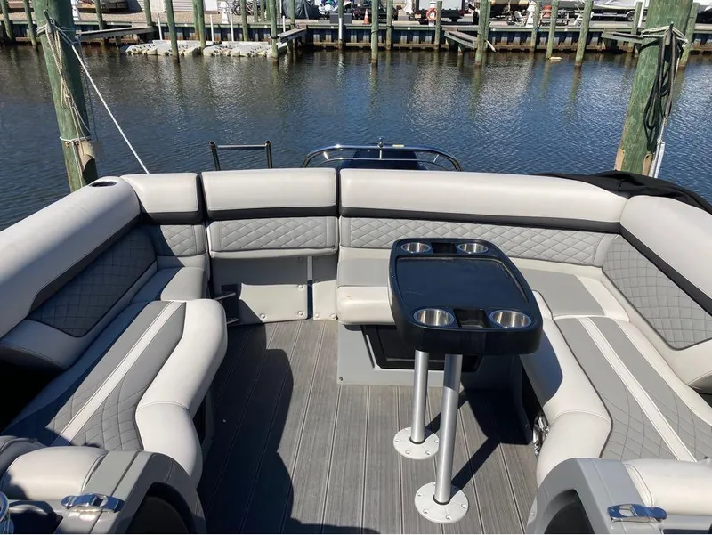 Slide: The Image of Luxury seating area on a 2020 Godfrey San Pan 26 pontoon boat at a marina. - 17