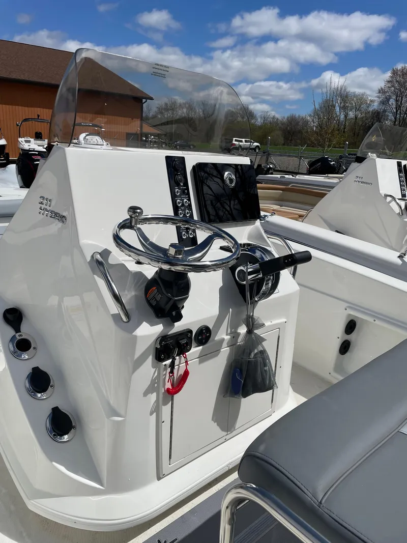 Slide: The Image of 2023 NauticStar 211 Hybrid boat console with steering wheel and controls. - 3