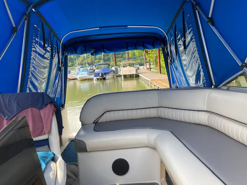 Slide: The Image of Interior of a 1994 Bayliner 2655 Cierra boat with blue canopy at a marina. - 18