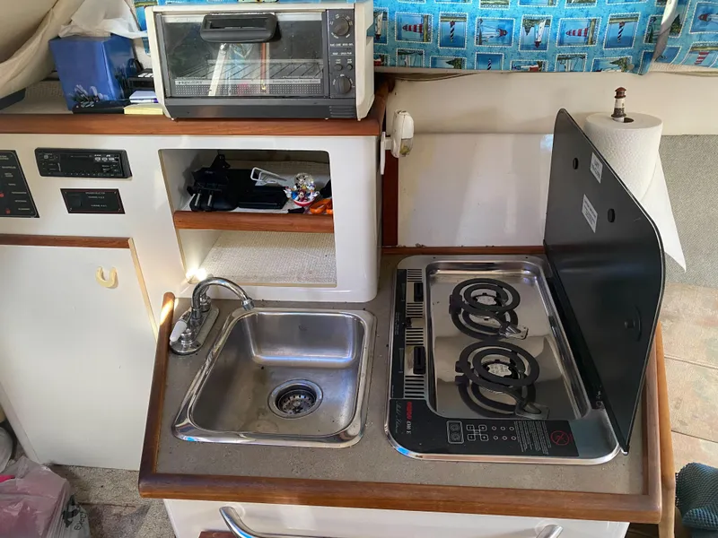 Slide: The Image of 1994 Bayliner 2655 Cierra kitchen area with sink, stove, and toaster oven. - 19