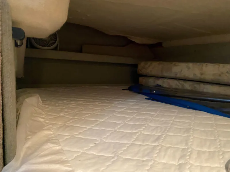 Slide: The Image of 1994 Bayliner 2655 Cierra cabin interior with bed and storage space. - 23