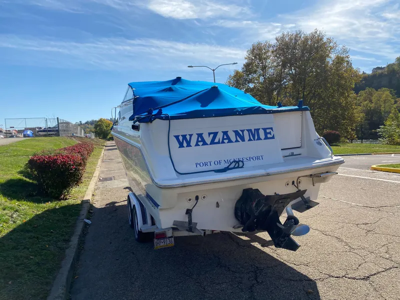 Slide: The Image of 1994 Bayliner 2655 Cierra boat with blue cover on trailer, parked on roadside. - 5