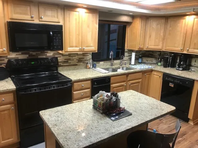 Slide: The Image of 2002 Sumerset Houseboat kitchen with granite countertops, modern appliances, and wooden cabinetry. - 10