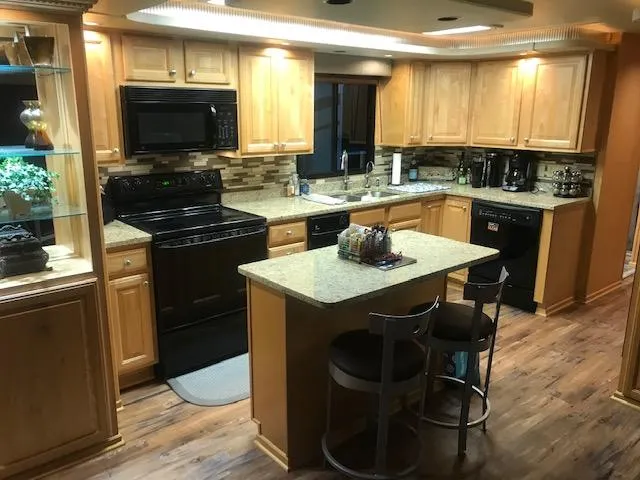 Slide: The Image of Modern kitchen in a 2002 Sumerset Houseboat with wooden cabinets and granite countertops. - 11