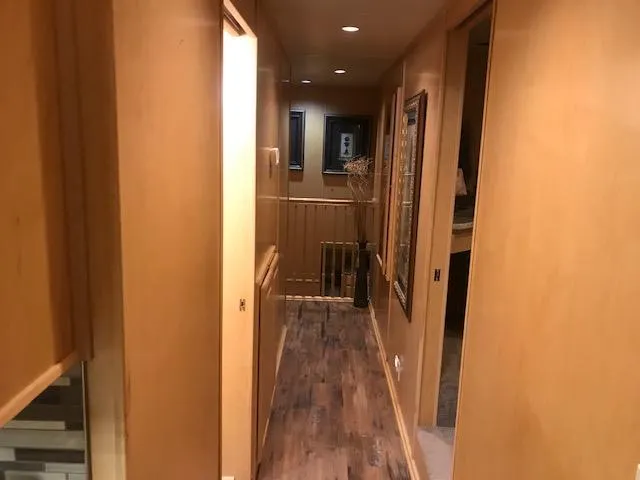 Slide: The Image of Narrow hallway inside a 2002 Sumerset Houseboat with wooden walls and flooring. - 15