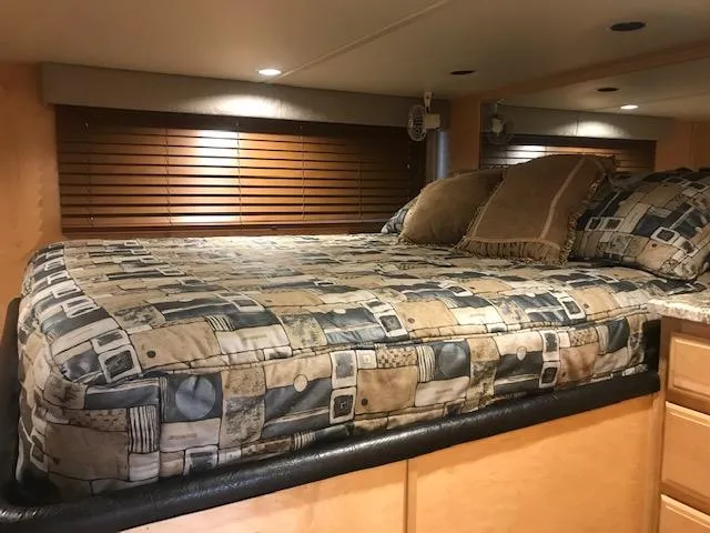Slide: The Image of 2002 Sumerset Houseboat bedroom with patterned bedding and wooden blinds. - 18