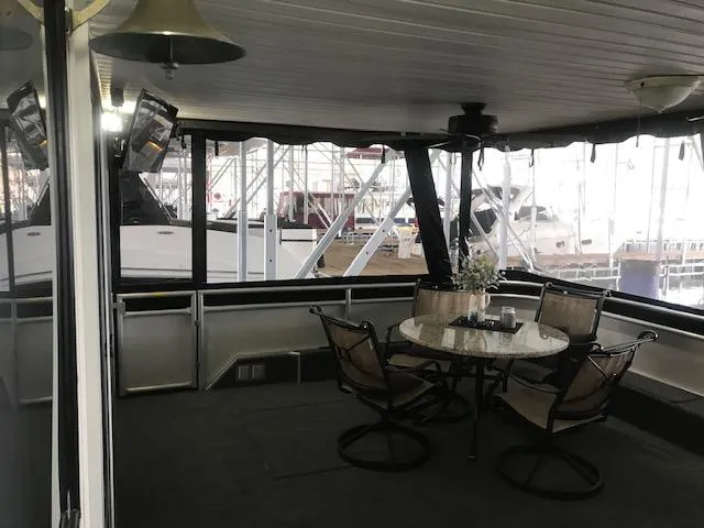 Slide: The Image of 2002 Sumerset Houseboat interior with dining area and marina view. - 2
