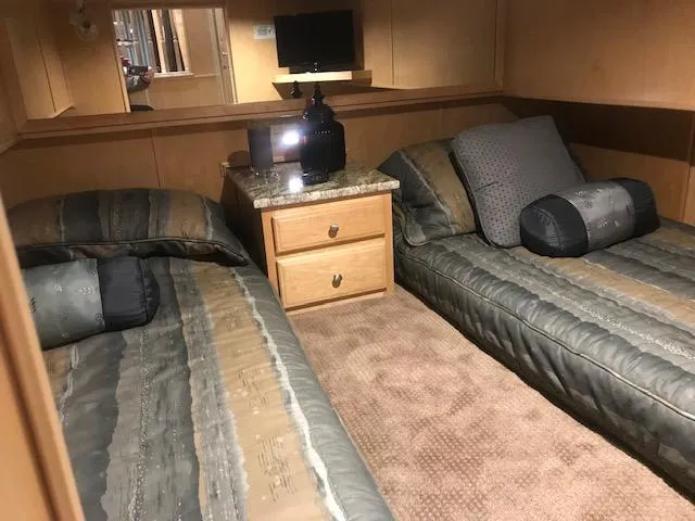 Slide: The Image of 2002 Sumerset Houseboat bedroom with twin beds and wooden nightstand. - 25