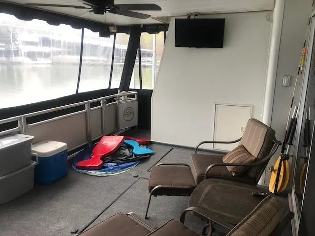 Slide: The Image of 2002 Sumerset Houseboat interior with seating, TV, and lake view. - 3