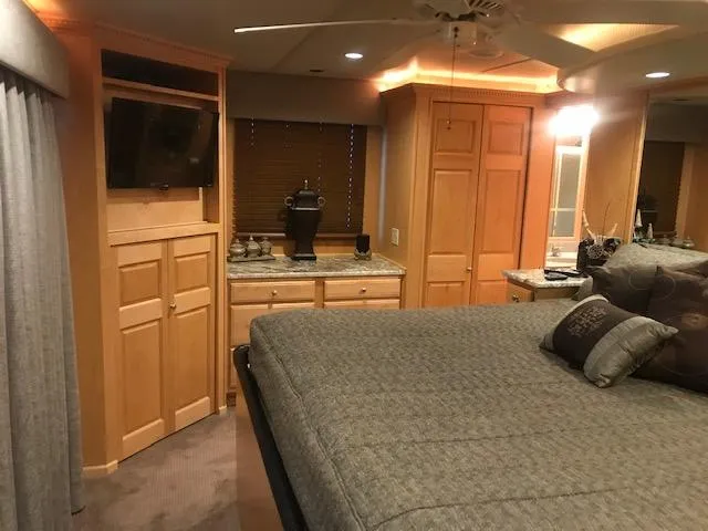 Slide: The Image of 2002 Sumerset Houseboat bedroom with TV, bed, and wooden cabinetry. - 30