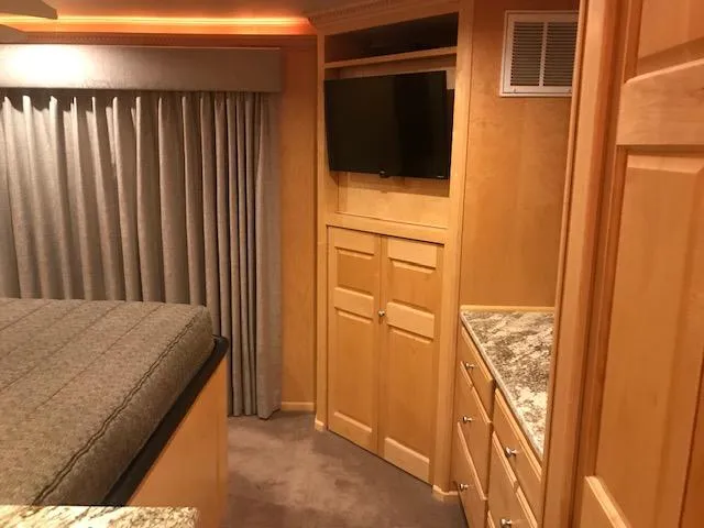 Slide: The Image of 2002 Sumerset Houseboat interior bedroom with TV, wooden cabinets, and granite countertops. - 33