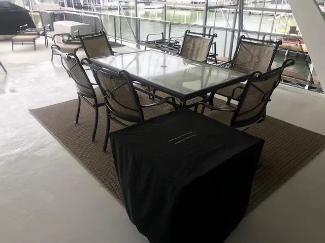 Slide: The Image of Outdoor dining area on a 2002 Sumerset Houseboat with glass table and chairs. - 42