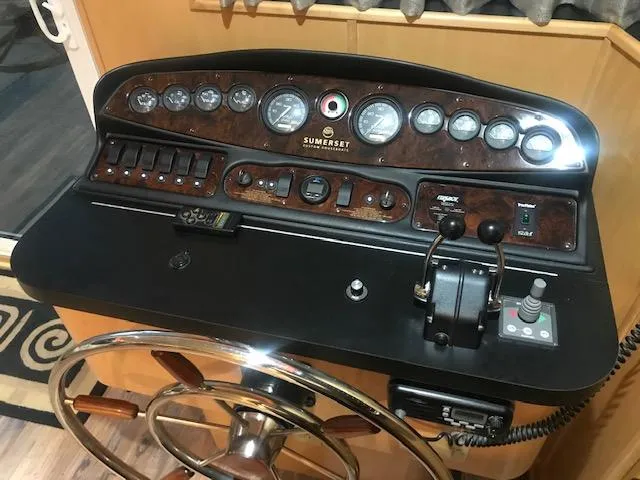 Slide: The Image of Control panel of a 2002 Sumerset Houseboat with steering wheel and gauges. - 5
