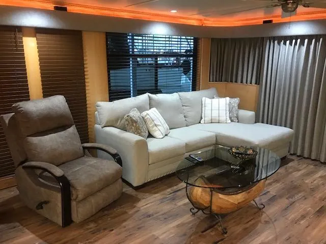 Slide: The Image of Interior of 2002 Sumerset Houseboat with cozy seating area, recliner, and glass coffee table. - 9