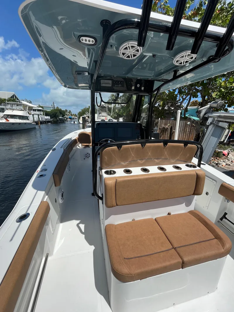 Slide: The Image of 2020 Sea Hunt 30 Gamefish boat with brown seating, docked in a sunny canal. - 12