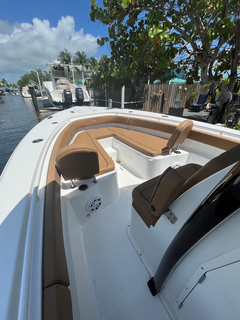 Slide: The Image of 2020 Sea Hunt 30 Gamefish boat with tan seating, docked by a waterfront. - 15