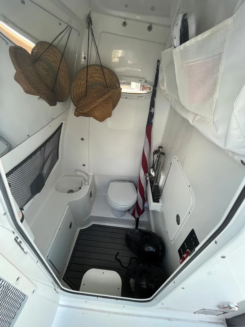 Slide: The Image of Interior of 2020 Sea Hunt 30 Gamefish boat with toilet and storage. - 16
