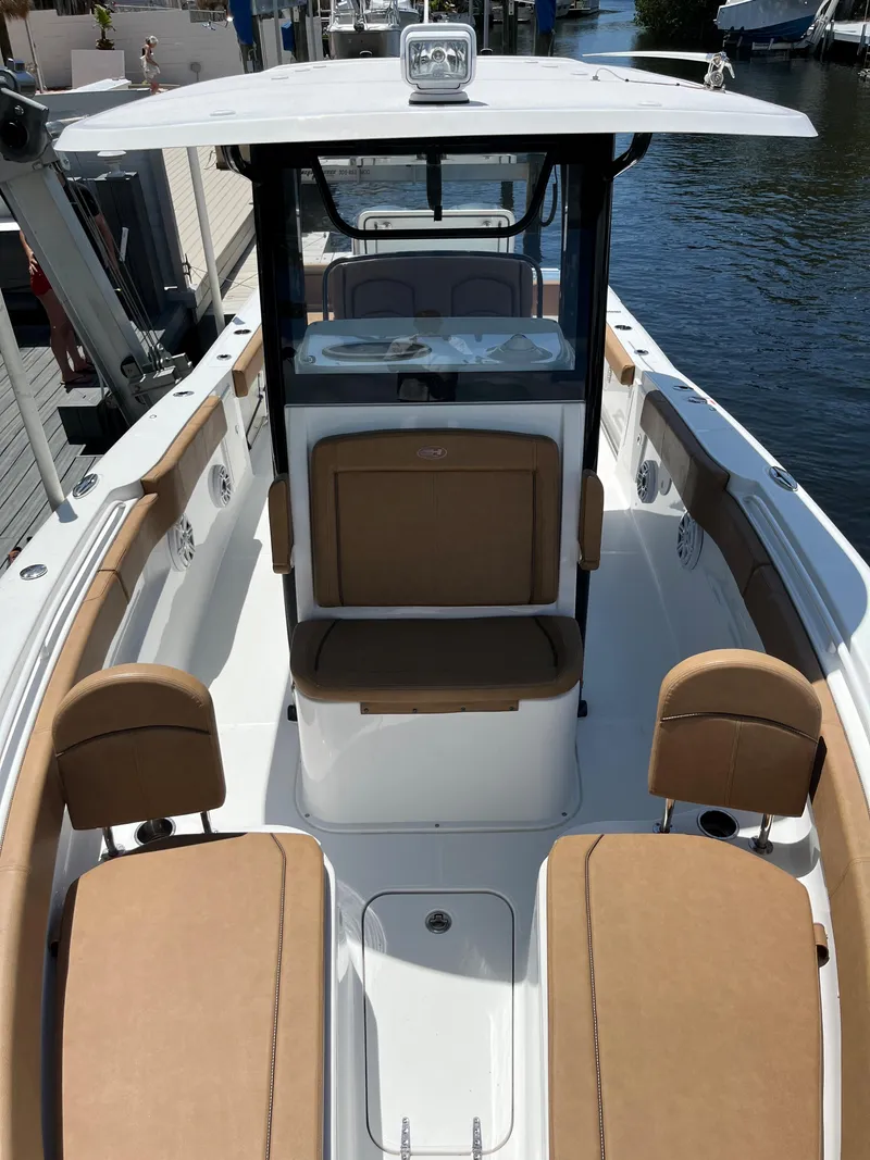 Slide: The Image of 2020 Sea Hunt 30 Gamefish boat with tan seating, docked on a sunny day. - 17
