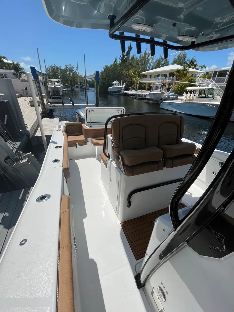 Slide: The Image of 2020 Sea Hunt 30 Gamefish boat interior with seating, docked in a marina. - 19