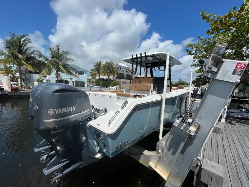 Slide: The Image of 2020 Sea Hunt 30 Gamefish boat with Yamaha engine docked under a sunny sky. - 4