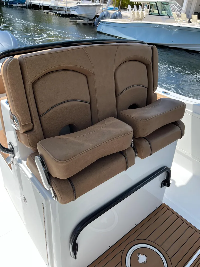 Slide: The Image of 2020 Sea Hunt 30 Gamefish boat with brown cushioned seats, docked by the water. - 8