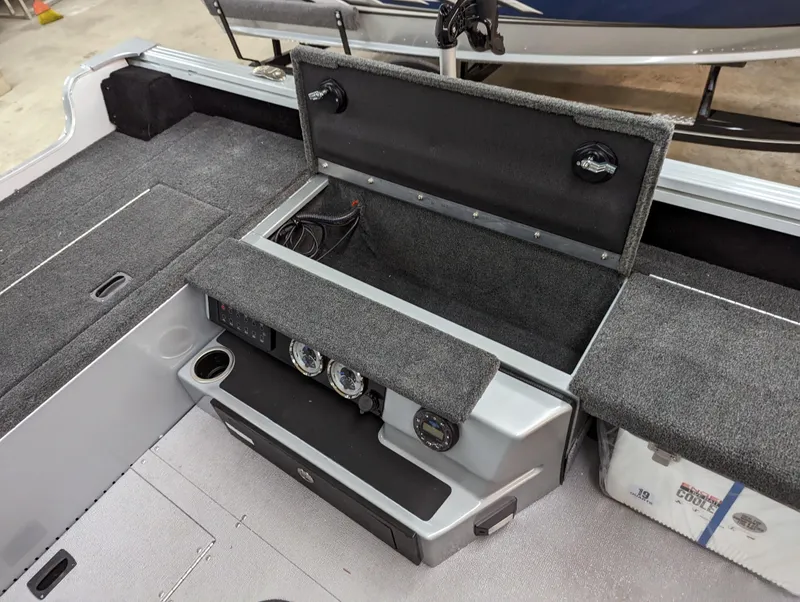 Slide: The Image of 2023 Smoker Craft Adventurer 188 T boat interior with open storage compartments and control panel. - 15