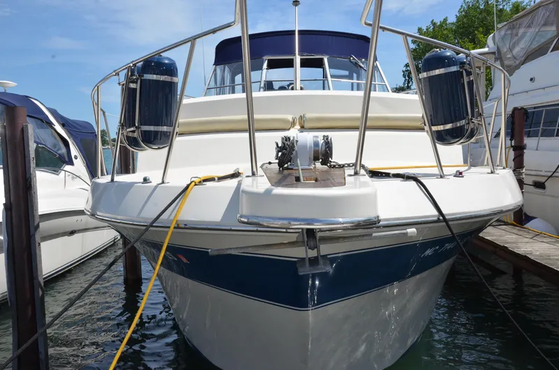 Slide: The Image of 1984 Chris-Craft 381 Catalina yacht docked, front view with blue accents and mooring lines. - 2