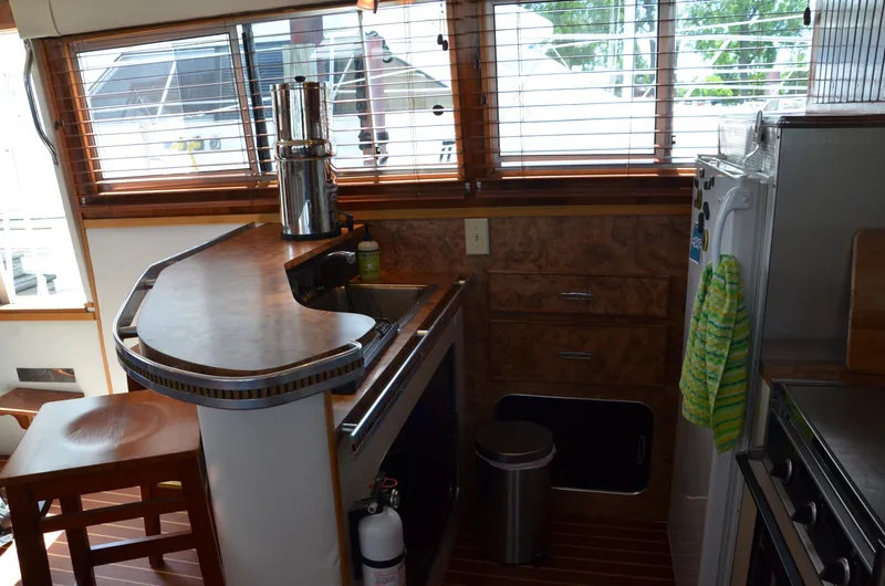 Slide: The Image of 1984 Chris-Craft 381 Catalina yacht interior with kitchen, wooden cabinetry, and bar seating. - 23