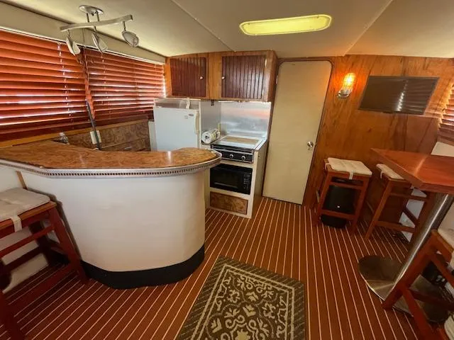Slide: The Image of 1984 Chris-Craft 381 Catalina interior with kitchen, bar, and wooden accents. - 27