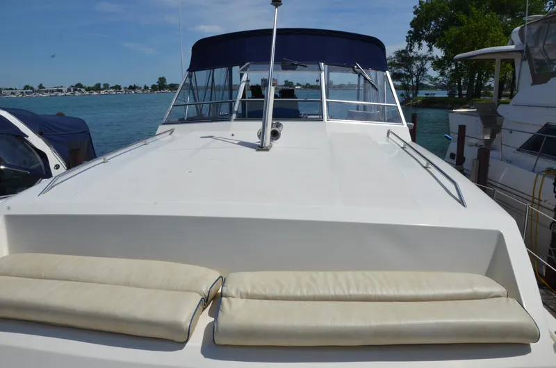 Slide: The Image of 1984 Chris-Craft 381 Catalina yacht docked, featuring spacious deck and blue canopy. - 3