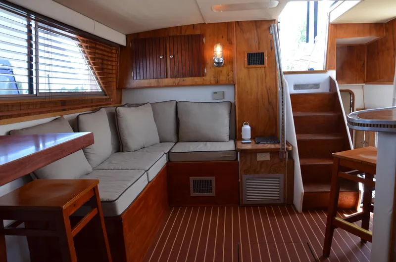 Slide: The Image of 1984 Chris-Craft 381 Catalina interior with wooden decor and cushioned seating. - 35