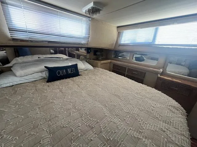 Slide: The Image of 1984 Chris-Craft 381 Catalina cabin interior with bed, pillows, and windows. - 39