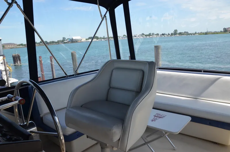 Slide: The Image of 1984 Chris-Craft 381 Catalina boat interior with helm seat and waterfront view. - 8