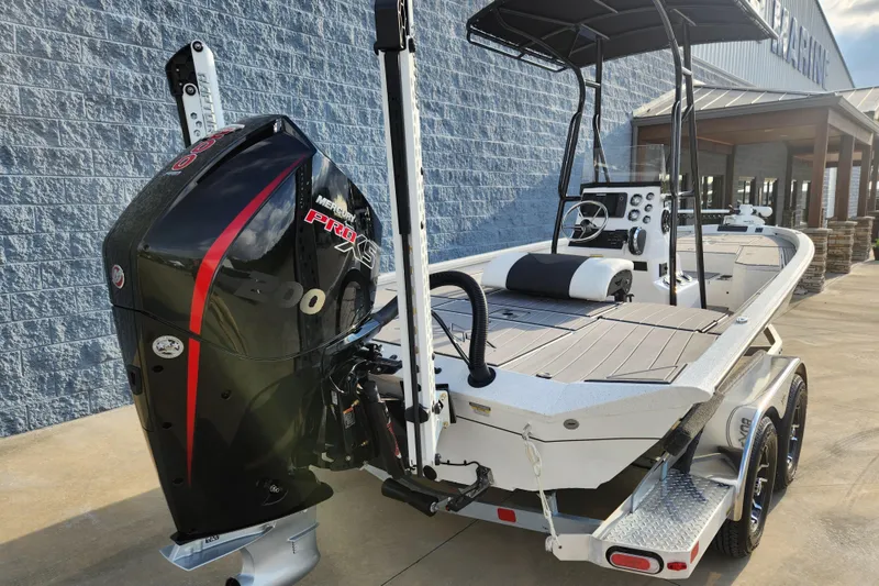 Slide: The Image of 2023 Vexus AVX2180CC boat with powerful outboard motor, docked outside a building. - 12