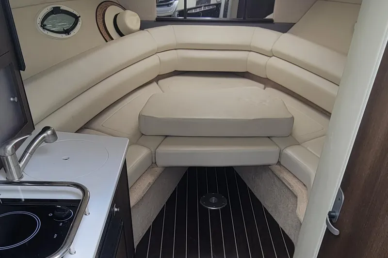 Slide: The Image of 2016 Monterey 275 Sport Yacht interior with kitchenette and cushioned seating area. - 10