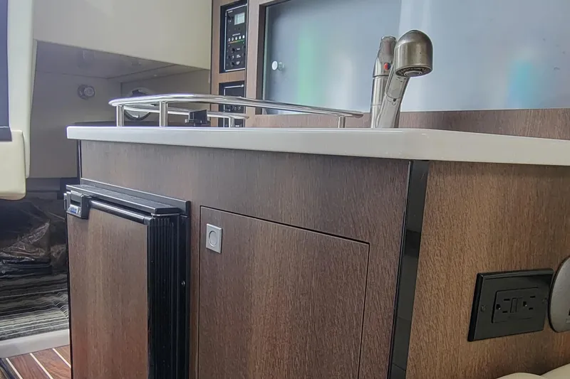 Slide: The Image of 2016 Monterey 275 Sport Yacht kitchen area with sink and cabinetry. - 12