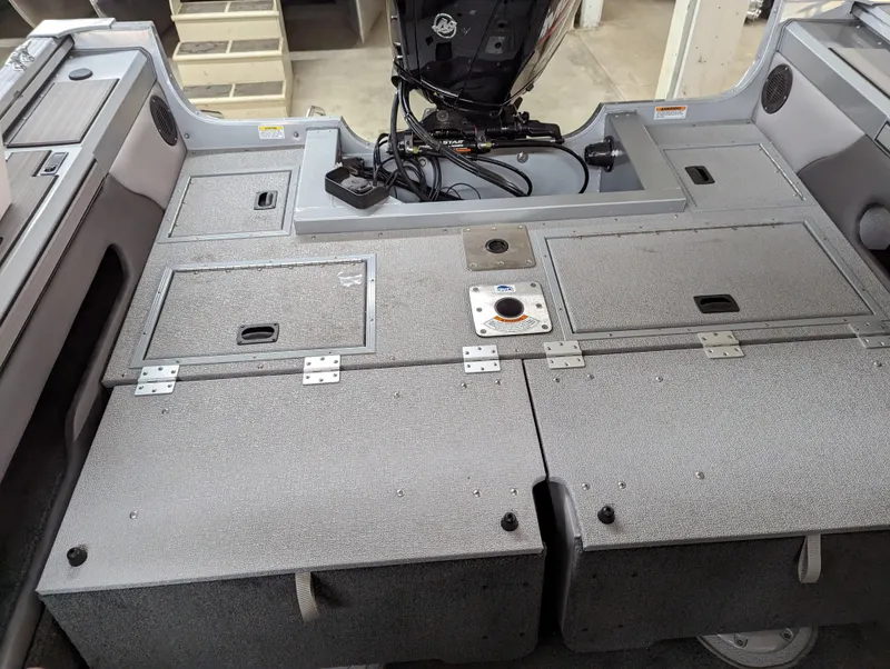 Slide: The Image of 2023 Smoker Craft Pro Angler XL 182 boat interior with storage compartments and motor. - 2