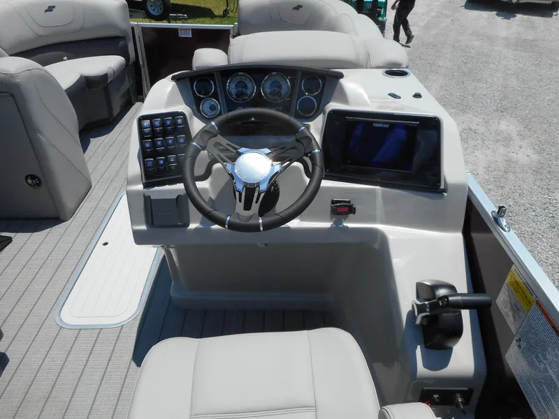 Slide: The Image of 2023 Starcraft CX 23 Q boat dashboard with steering wheel and control panel. - 12